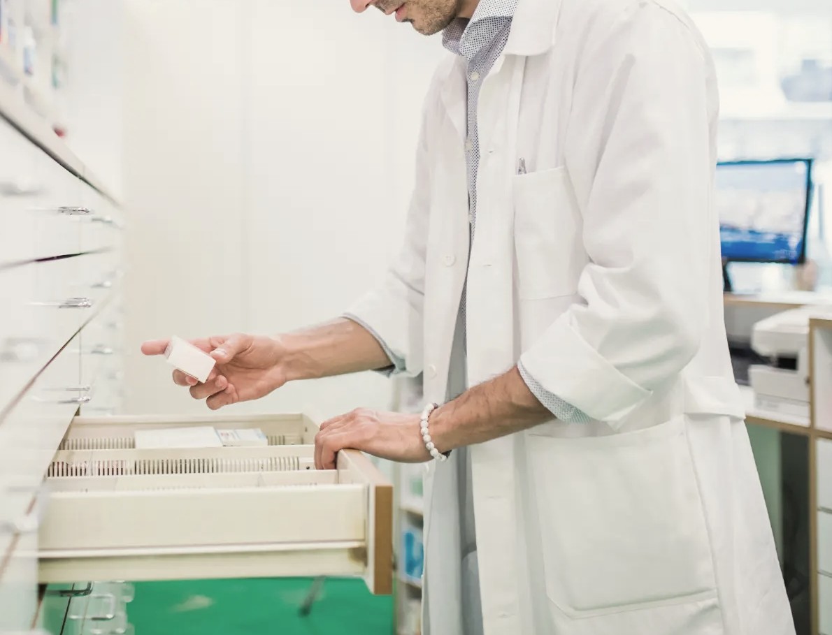 Pharmacist selecting a medication from a pharmacy drawer