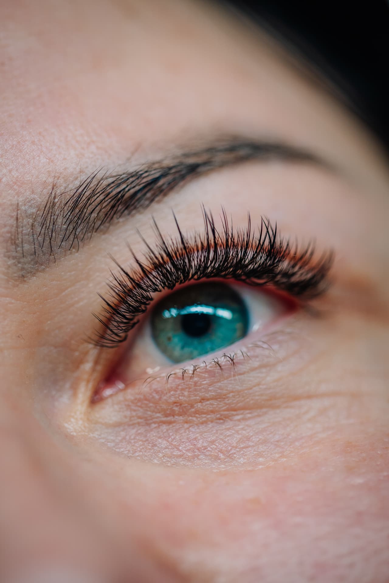 Macro close-up of a blue eye with long, full lashes