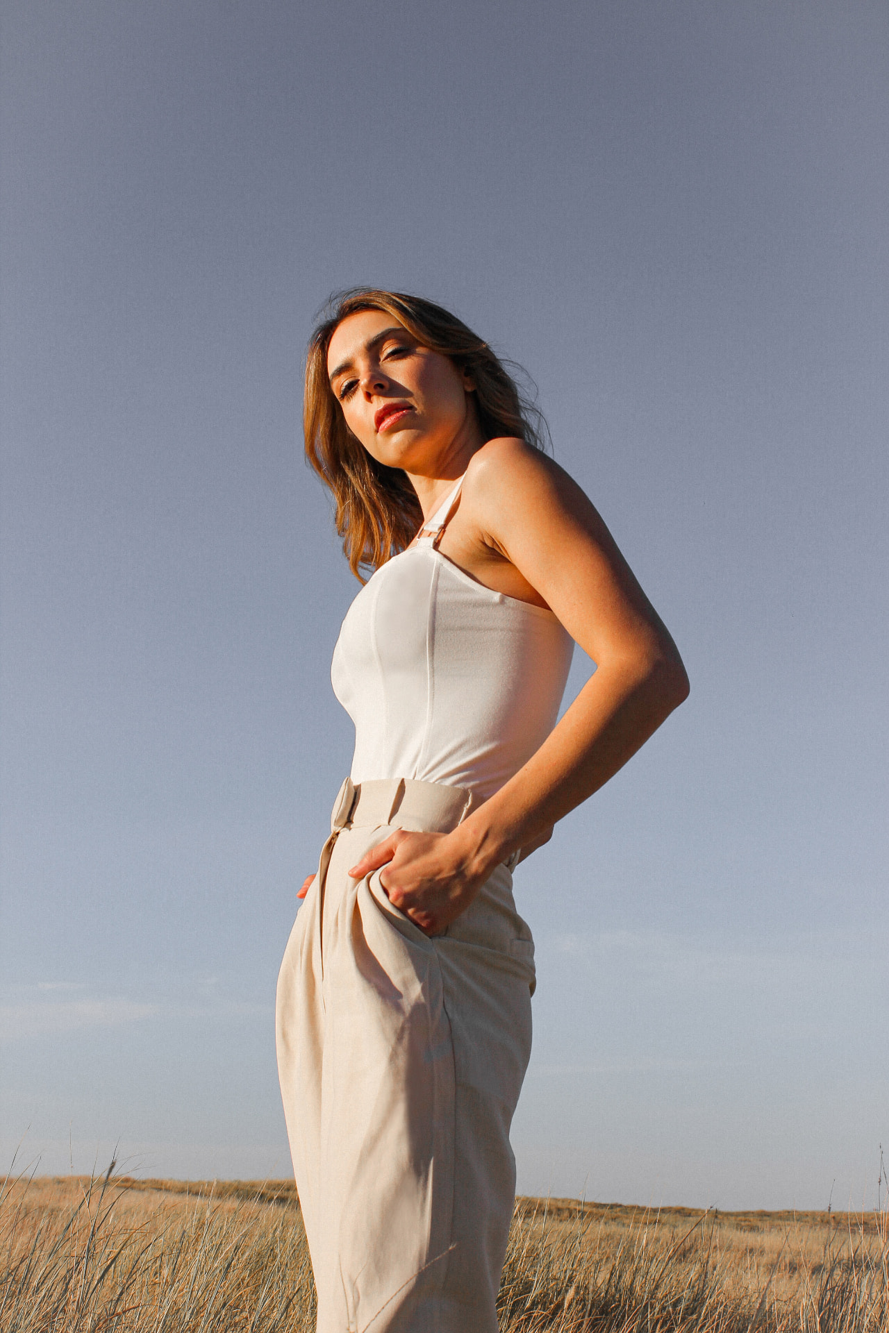 Woman in neutral linen standing in open golden field light